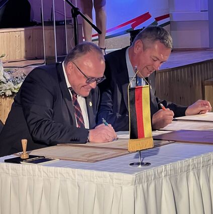 Külsheims Bürgermeister Thomas Schreglmann (links) und János Zádori, Bürgermeister von Pécsvárad, unterzeichnen Erneuerungsurkunden hinsichtlich der Partnerschaft.