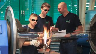 Enrico Mehl und Robin Kettner (von links) absolvieren bei Lenz Laborglas eine Ausbildung zum Glasapparatebauer. Eine der Grundtechniken an der Drehbank ist das Verengen von Rohren, das den beiden Azubis gerade von Waldemar Ajrich, Mitglied im Prüfungsausschuss für Glasapparatebauer der IHK Heilbronn und Lehrer am Beruflichen Schulzentrum sowie Beiratssprecher des VDG, genau erklärt wird.