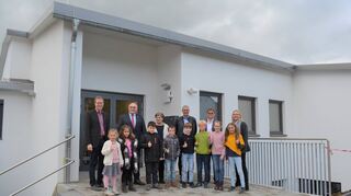 Daumen hoch für die Taubergrundschule: Gemeinsam mit Schülern freuten sich (von links) Kersten Hahn, der Fachbereichsleiter „Bildung“, OB Udo Glatthaar, Schulleiterin Suzanne Schorn, Ortsvorsteher Detlef Heidloff, Architekt Max Ertel und Sabine Mangold (Sachgebietsleiterin Schulen) über den Unterrichts-Start im Neubau.