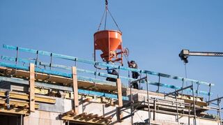 Arbeiter leeren auf der Baustelle eines Mehrfamilienhaus Beton aus. Rückgänge der Bautätigkeit sind bundesweit vor allem im privaten Wohnungsbau spürbar, regionale Unternehmen äußern sich auf Nachfrage dennoch optimistisch fürs nächste Jahr.