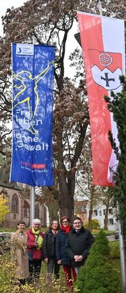 Landrat, Sozialdezernentin und Vereins-vertreterinnen von Frauen helfen Frauen vor der Fahne.