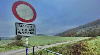 Ein Schild weist auf den an dieser Stelle nicht asphaltierten Weg in Richtung Dienstadt hin.