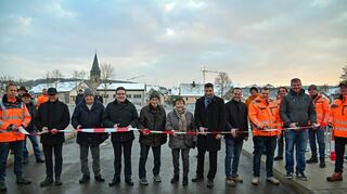 Das Absperrband auf der neuen Tauberbrücke durchschnitten (von links): Christian Meißner (stellvertretender Leiter Straßenbauamt), Ortsvorsteher Hans-Joachim Haas, der älteste Einwohner Elpersheims, Harry Welm, Landrat Christoph Schauder, die Elpersheimer Bürger Helmut Lang und Ruth Stirnkorb, Bürgermeister Nick Schuppert, vom Bauunternehmen Leonhard Weiss Sascha Bißwanger, Philipp Wieland und Michael Hallmeyer sowie Straßenbauamtsleiter Markus Metz.