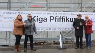Freuen sich mit Banner auf die Fertigstellung des neuen Kindergartens und die Zusammenarbeit: (von links) Kerstin Rupp (künftige Leiterin), Rainer Friedrich (Geschäftsführer St. Josefspflege Mulfingen), Oberbürgermeister Udo Glatthaar und Andreas Berns (Sachgebietsleiter Kinderbetreuung).