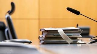 Akten liegen vor Beginn eines Prozesses am Platz des vorsitzenden Richters am Landgericht. +++ dpa-Bildfunk +++