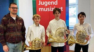 Über einen ersten Preis beim Landeswettbewerb freuen sich das Horn-Trio mit Julian und Maximilian Lasarenko sowie Johann Rechenberg und ihr Lehrer Michael Geiger. Foto: Musikschule Wertheim