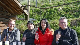 Na, dann „Prost“!: Tobias Nägele, Arnd Richter, Ilka Zwieb und Dr. Achim Brötel mit dem Jubiläums-Kreisler im Glas und den noch jungen Regent-Rebstöcken am Hang hinter sich.