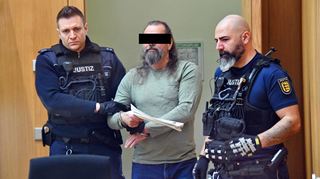 Ingo K. wird mit Handschellen in den Gerichtssaal geführt: Doch der angeklagte frühere Kampfsporttrainer gibt sich beim Prozessauftakt entspannt.