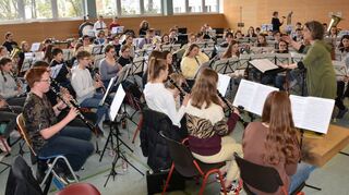 Dirigentin Julia Köstlin probt mit dem Kreisjugendblasorchester in der Aula der Kaufmännischen Schule Tauberbischofsheim.