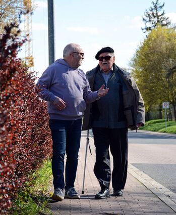 Nikolaus Hildenbrand (links) und Hans Kimmel flanieren die Willy-Brandt-Straße entlang. Auf ihrem Weg diskutieren die Männer, die der Besuchsdienst der Malteser zusammengebracht hat, über Baugewerbe, Nachhaltigkeit und das Leben.