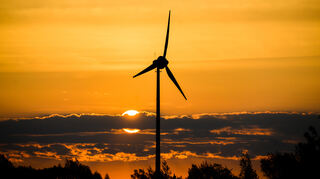 Die Sonne geht hinter Windrädern auf. +++ dpa-Bildfunk +++
