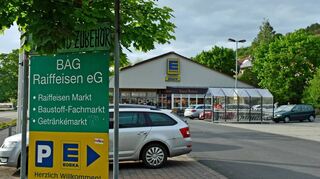 Die Parkflächen für BAG- und Edeka-Markt befindet sich zwischen den beiden Bauten an der Bad Mergentheimer Straße in Creglingen. In Blickrichtung hinter dem bestehenden Gebäude soll für Edeka eine Nordwest-Erweiterung umgesetzt werden. Der neue Komplex rückt damit an die bestehenden Blockhäuser heran.