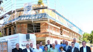 Links: Die Bona Wohnungsgesellschaft mbH feierte im Badweg 14 Richtfest am dort entstehenden „Stiftungshaus“ der ARBAnova-Familienstiftung. Das Stifterehepaar Marianne (mit Blumenstrauß) und Reinhold Barlian (rechts daneben) freute sich zusammen mit den Gästen über den sehr gelungenen Neubau, denn damit konnten sie an exponierter Stelle einen Beitrag zur Erneuerung und Aufwertung des Badwegs leisten. Rechts: Ein Schmuckstück direkt am Eingang zum Kurpark – so wird sich das „Stiftungshaus“ der ARBAnova-Familienstiftung nach der Fertigstellung im Frühjahr 2024 dem Betrachter präsentieren.