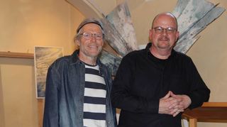 Der Künstler Björn Hausschild und Pfarrer Dr. Kücherer bei der Ausstellungseröffnung in der Wenkheimer Synagoge. Im Hintergrund einige der ausgestellten Bilder von Hausschild.
