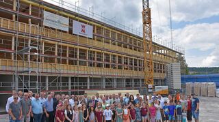 Oberbürgermeister, Rathaus-Mitarbeiter, Stadträte, Handwerker, Schulvertreter, Schüler und Eltern freuen sich gemeinsam über den Neubau.