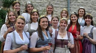„Hahn“ im Korb: Intendant Lars Wernecke mit Röttingens Weinprinzessin „Anne I“ Düll und den Weinhoheiten der Region beim 40. Jubiläumsempfang im Paracelsus-Gärtchen der Burg Brattenstein.