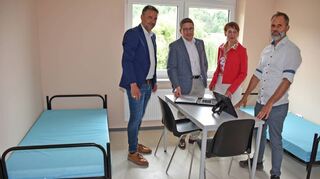 Landrat Christoph Schauder freut sich gemeinsam mit Sozialdezernentin Elisabeth Krug, Finanzdezernent Torsten Hauck und weiteren Mitarbeitern über die generalsanierte Kreis-Immobilie.