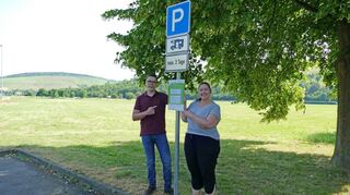 Christina Ort und Sebastian Kuhn vom Sachgebiet Tourismus, Kultur, Messe beim Anbringen eines neuen, aktuellen Hinweisschildes an den Wohnmobilstandorten im Stadtgebiet.