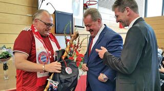 Von den Kollegen erhielt Ottmar Dürr aus Händen Thomas Schreglmanns (links) und Frank Menikheims (rechts) einen Rucksack, der mit Devotionalien, die ein Bayernfan braucht, gefüllt war. MdL Wolfgang Reinhart würdigte Dürr mit einer Gedenkmedaille.