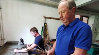 Während Siegried Friedrich die Unterlage (amerikanisches Rebenholz) begutachtet, schneidet Martin Edelreis und Unterlage passend. In der Hochsaison wird dieser Schritt von mehreren Arbeitern ausgeführt.