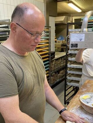 FN-Reporter Martin Bernhard formt Baguettes (links), während Bäckergeselle Sedat Weniger mit der Laugenmaschine Brezelteiglinge einlaugt.
