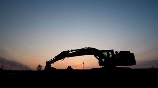 Ein Bagger steht bei Sonnenaufgang an einem Neubaugebiet. Um den Flächenverbrauch einzudämmen, fordern 24 Trägerorganisation im Land ein Netz „Agenturen für Innenentwicklung“.