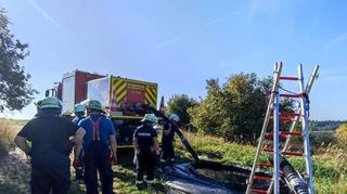 Aus dem Abrollbehälter werden die 5000 Liter Wasser in ein Bassin entleert, von dem aus die Löschfahrzeuge befüllt werden (linkes Bild). Das Betanken des Abrollbehälters der FFW Bad Mergentheim erfolgte in Schirmbach durch die Feuerwehr Creglingen.