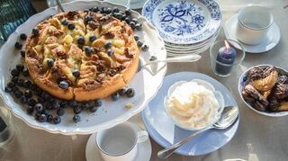 Mix & Match: Die Kaffeetafel besteht aus einem Service alter Stücke mit Zwiebelmuster, dazu werden neue einfarbig blaue und weiße Stücke kombiniert.
