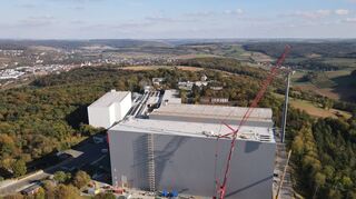 Oberhalb der Kurstadt und des Taubertals wächst der Industriepark Würth weiter. Hier werden gerade Regalbediengeräte durchs Dach eingehoben.