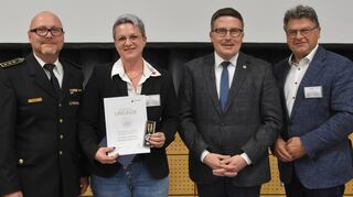Stefanie Breidenbach wurde für ihren selbstlosen Einsatz beim Hochwasser 2021 im Ahrtal mit der Verleihungsurkunde und der Fluthilfe-Medaille Rheinland-Pfalz und Baden-Württemberg ausgezeichnet. Das Bild zeigt (von links) Kreisbrandmeister Andreas Geyer, Stefanie Breidenbach, Landrat Christoph Schauder und den Vize-Präsidenten des Kreisverbands Bad Mergentheim Klaus Kornberger.