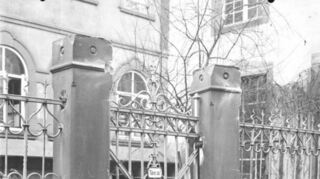 Dort, wo früher ein eingezäunter Hof mit Bepflanzung war, ist heute ein Parkplatz: Das gesuchte Bild ist die Rückseite des Hauses 49 in der Eichelgasse. Früher war dort die Volksbank untergebracht.