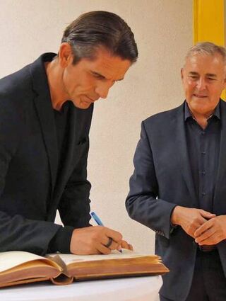 Der Stargast beim Eintrag ins goldene Buch. Rechts Bürgermeister Markert.