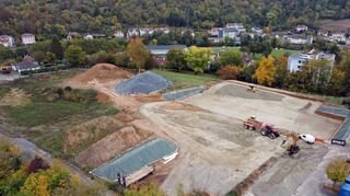 Auf dem Gelände des früheren Krankenhauses soll (links) das neue Wohngebiet entstehen. Rechts die Baugrube der neuen Sporthalle.