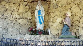 Die Lourdes-Grotte oberhalb des Wallfahrtsplatzes zeigt die Muttergottes und rechts daneben kniend die Statue der Heiligen Bernadette.