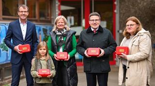 An der Christian-Morgenstern-Grundschule in Tauberbischofsheim präsentierten (von links) Peter Vogel, Vorstandsvorsitzender der Sparkasse Tauberfranken, Erstklässlerin Hedda Jahn, Bürgermeisterin Anette Schmidt, Landrat Christoph Schauder und Schulleiterin Julia Schindler die „Sattmacher-Box“.