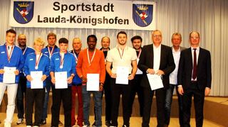Die Empfänger der Einzelleistungsklasse „Goldbarren und Goldmedaillengewinner Einzelsportler“ gemeinsam mit Bürgermeister Dr. Lukas Braun (rechts) sowie den beiden Moderatoren Hartmut Schwartz (Zweiter von rechts) und Matthias Götzelmann (Vorsitzender des Sportkreises Tauberbischofsheim, links).