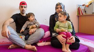 Eine syrische Flüchtlingsfamilie in ihrem Wohnbereich in einer Flüchtlingsunterkunft..