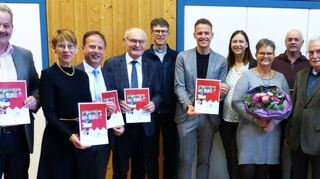 Bei der Adventsfeier der Lebenshilfe Main-Tauber-Kreis im Dorfgemeinschaftshaus Kupprichhausen stellte Vorsitzender Benjamin Czernin (Sechster von links) das Jahresprogramm für 2024 vor und überreichte die ersten Exemplare.