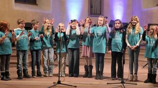 Mit viel Bewegung stimmte der Schulchor (links) auf Weihnachten ein. Alle Mitwirkenden (rechts) wünschten sich mit John Lennons „War is over“ ein Weihachten ohne Kriege.