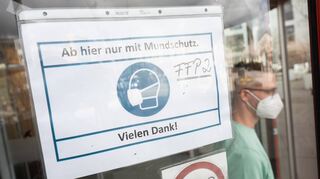 Ein Mann mit FFP2-Maske geht an einem Schild vorbei, das auf die Maskenpflicht hinweist. Bislang hat nur das Caritas-Krankenhaus eine solche Pflicht wieder eingeführt, andere Häuser halten die Maßnahme für nicht notwendig.