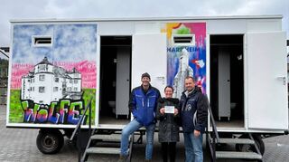 Karlheinz Haas (links), Jenny Heilig und Michael Grimm vor dem neu gestalteten Toilettenwagen der FG „Hordemer Wölf“. Dieser soll zukünftige Veranstaltungen in der Erftalgemeinde bereichern.