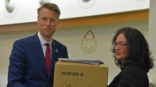 Tanja Stroisch übergibt die Kiste mit den Unterschriftenlisten OB Markus Herrera Torrez.