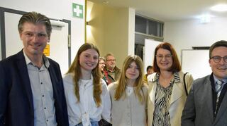 Landrat Christoph Schauder (rechts) gratuliert Frank Menikheim zu dessen Wiederwahl als Igersheimer Bürgermeister. Mit ihm freut sich auch dessen Familie.