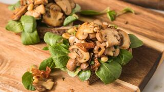Pilze werden als natürlicher Fleischersatz immer populärer. Statt einer Wurststulle, kann man die Brotscheibe auch mit Champignons, getrockneten Tomaten und Feldsalat belegen.