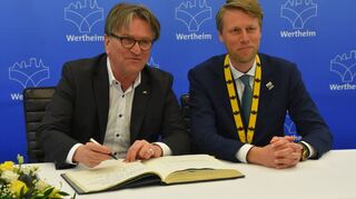 Manfred Lucha trägt sich ins Goldene Buch der Stadt Wertheim ein.