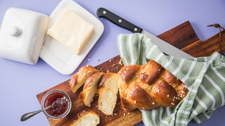 Frisch aus dem Ofen: Der mit Hagelzucker bestreute Hefezopf wird aufgeschnitten und am besten mit Butter oder Erdbeer-Marmelade bestrichen.