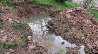 Nach einem Jahr „auf dem Trockenen“ kann der Wessentaler Dorfbrunnen wieder fließen: Das viele Wasser im Graben zeigt, dass unterirdisch eine Quelle aus dem Felsen kommt.
