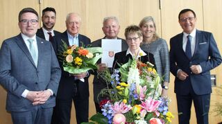 Zur Verleihung der Bürgermedaille an Rolf Mailänder (Dritter von links), Günter Breitenbacher (Mitte) und Hartwig Behr, dessen Witwe Christa Behr (Dritte von rechts) die postum verliehene Auszeichnung von Bürgermeister Nick Schuppert (Zweiter von links) entgegennahm, gratulierten mit der Bundestagsabgeordneten Nina Warken, Landtagsvizepräsident Wolfgang Reinhart (rechts) und Landrat Christoph Schauder (links) auch hochrangige Repräsentanten von Kreis, Land und Bund.