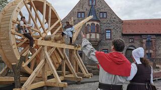„Sehet her, holdes Weib“: Ein mittelalterlicher Lastenkran, der über ein Rad angetrieben wird, ist ein Nachbau nach aus der Zeit stammenden Unterlagen (aus dem Museum in Mannheim) und eine der Neuheiten, auf die (von links) Nicolai Seitz, Ralf Dorbath, Peter Betzel und Claudia Thum vom Organisationsteam stolz sind. Die Arbeiten daran dauerten einige Monate.