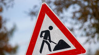 Ein zerkratztes Schild Gefahrzeichen Arbeitsstelle (Zeichen 123) mit dem Piktogramm eines Bauarbeiters zur Beschilderung einer Baustelle steht in der Gemeinde Sauzin auf der Insel Usedom. +++ dpa-Bildfunk +++